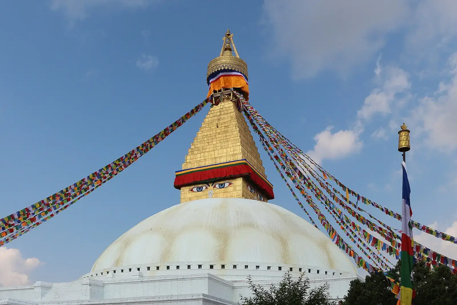 The white dome and golden spire of Boudhanath Stupa with prayer flags, Kathmandu