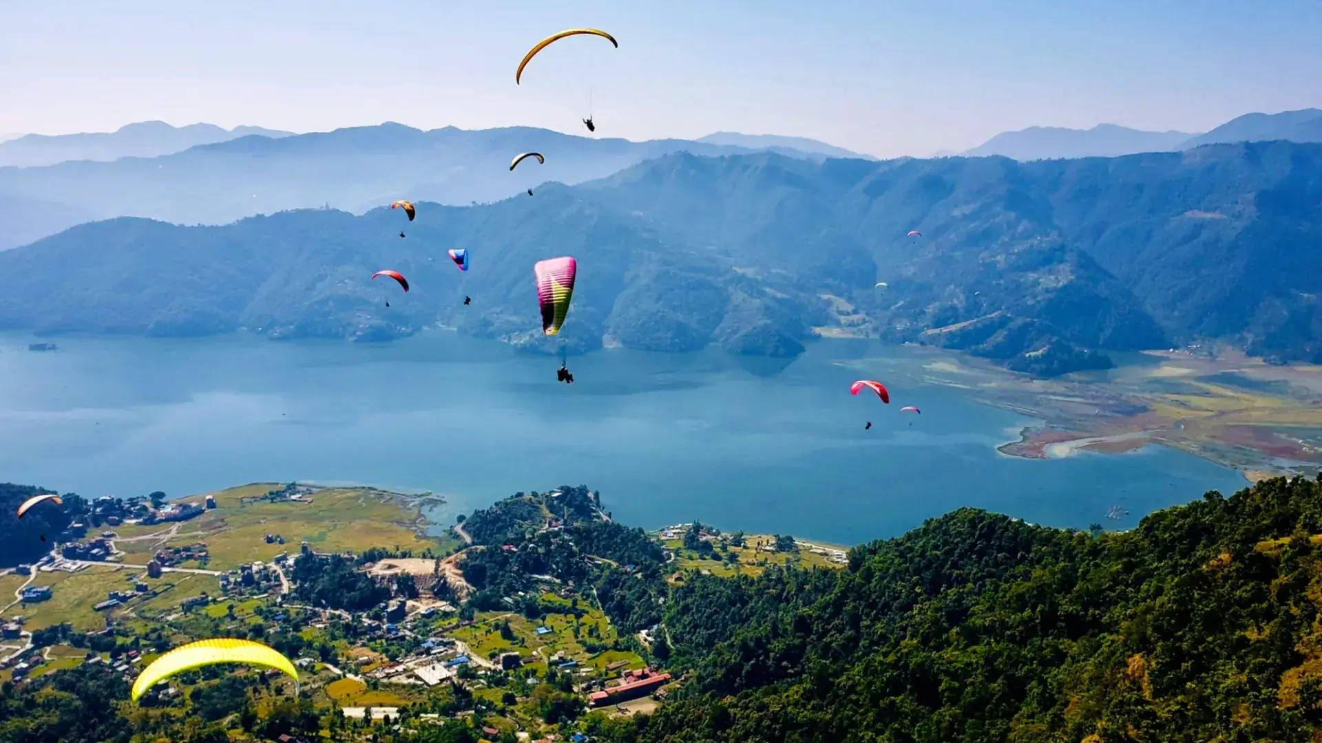 Paragliders above Phewa Lake and the green hills of Pokhara