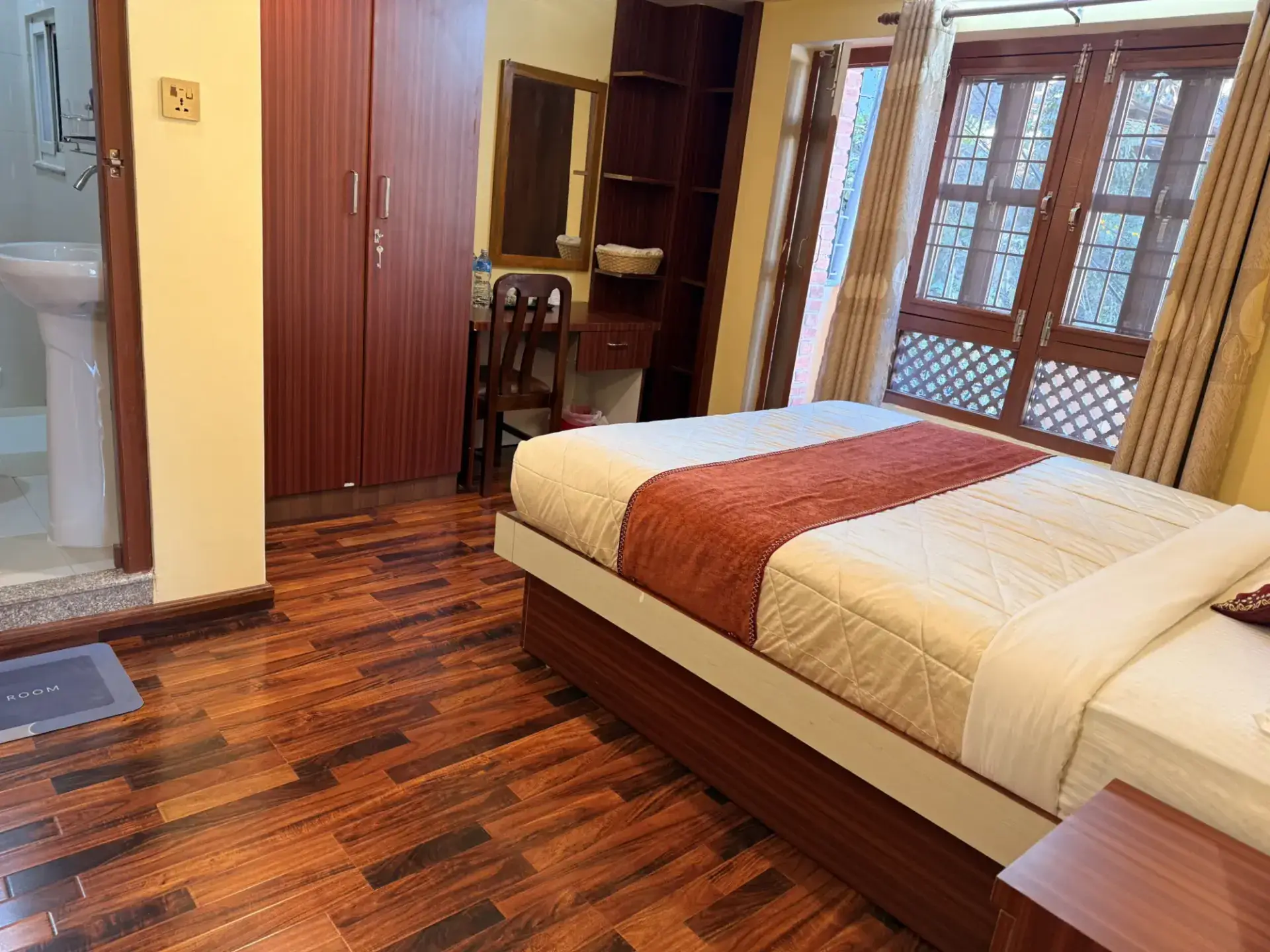 Bright Deluxe King Room with carved wooden windows and fresh white linen