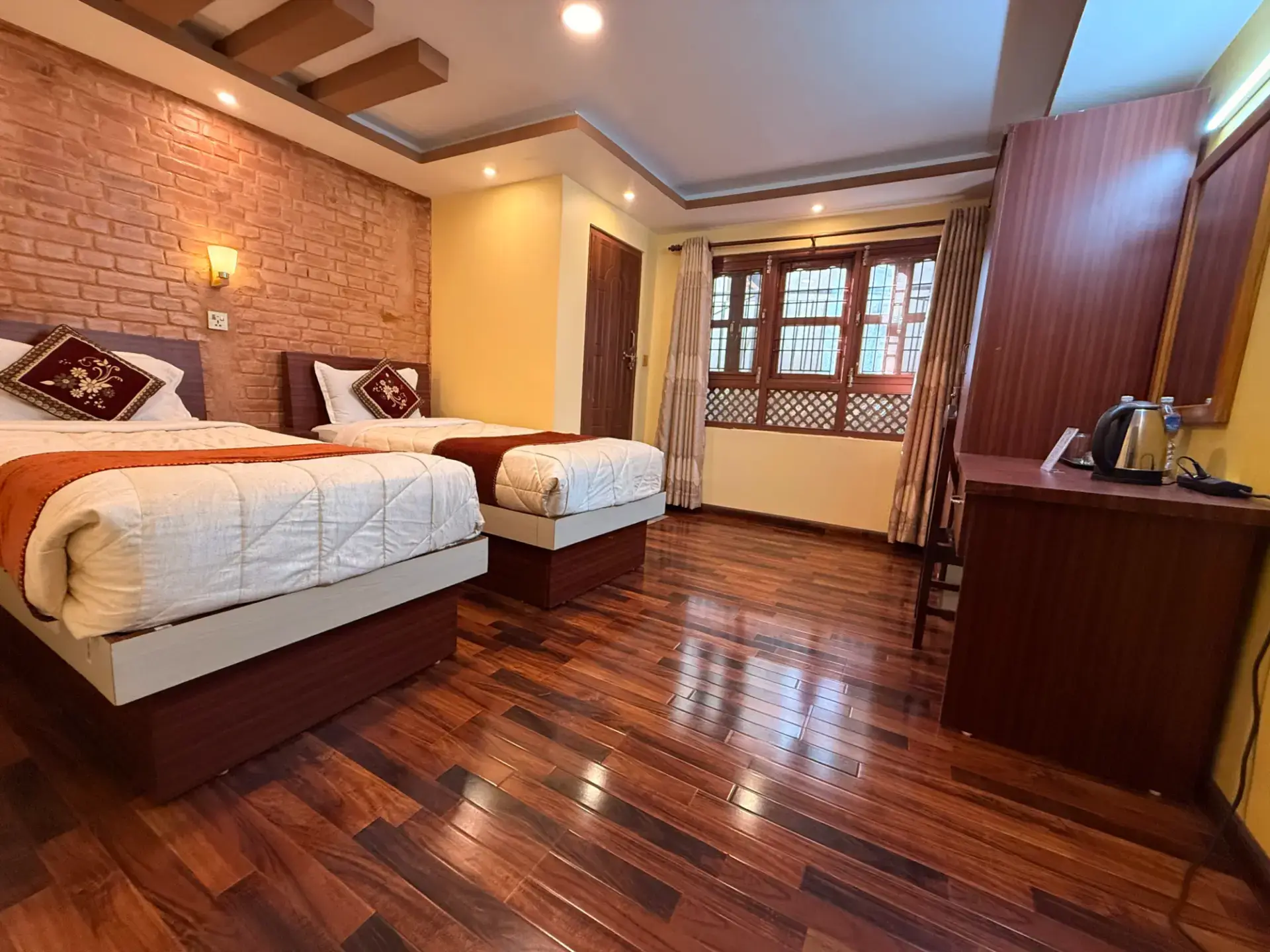 Deluxe Twin Room with two single beds, brick feature wall and wooden floor