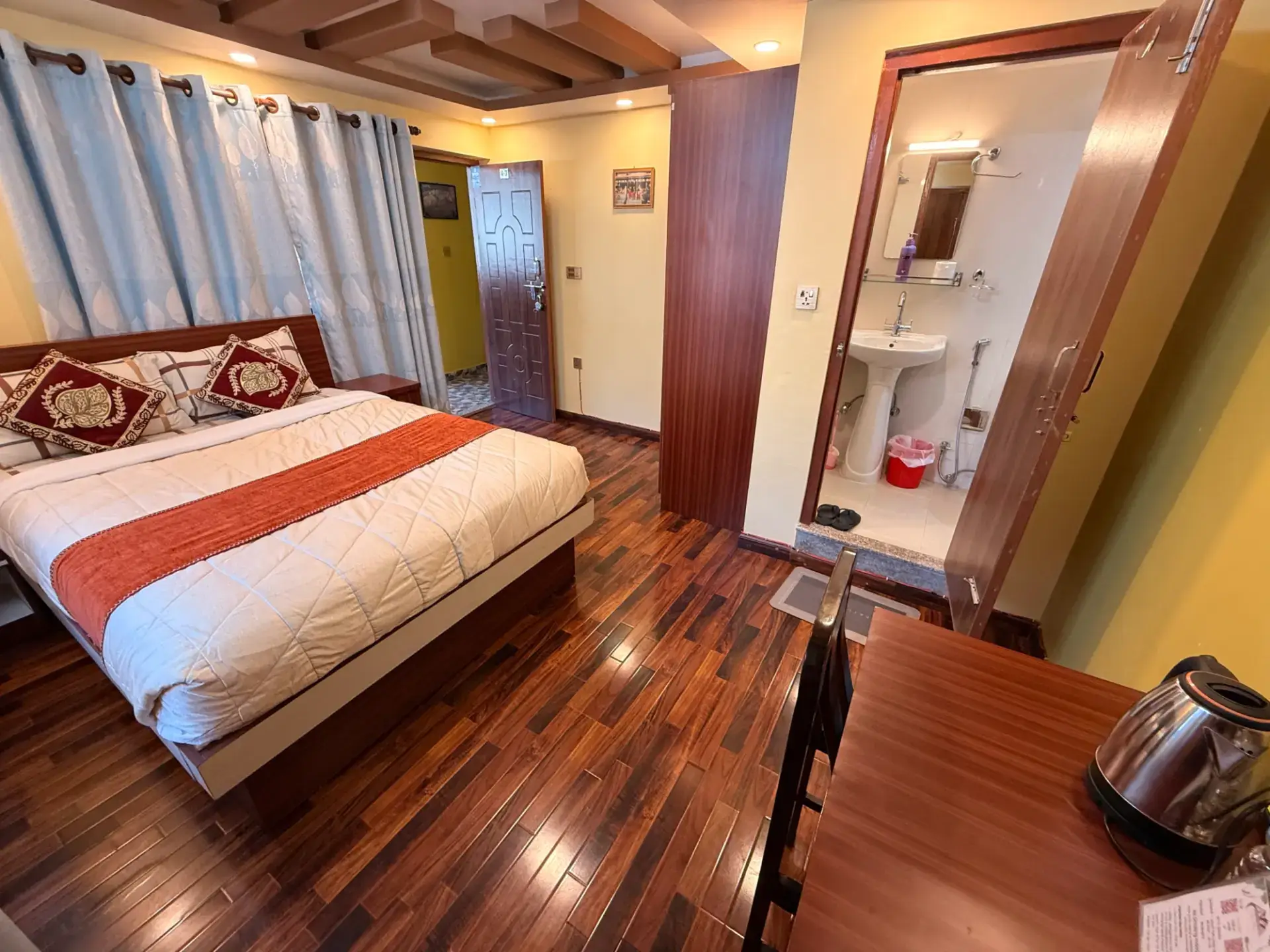 King room with en-suite bathroom door, desk and kettle