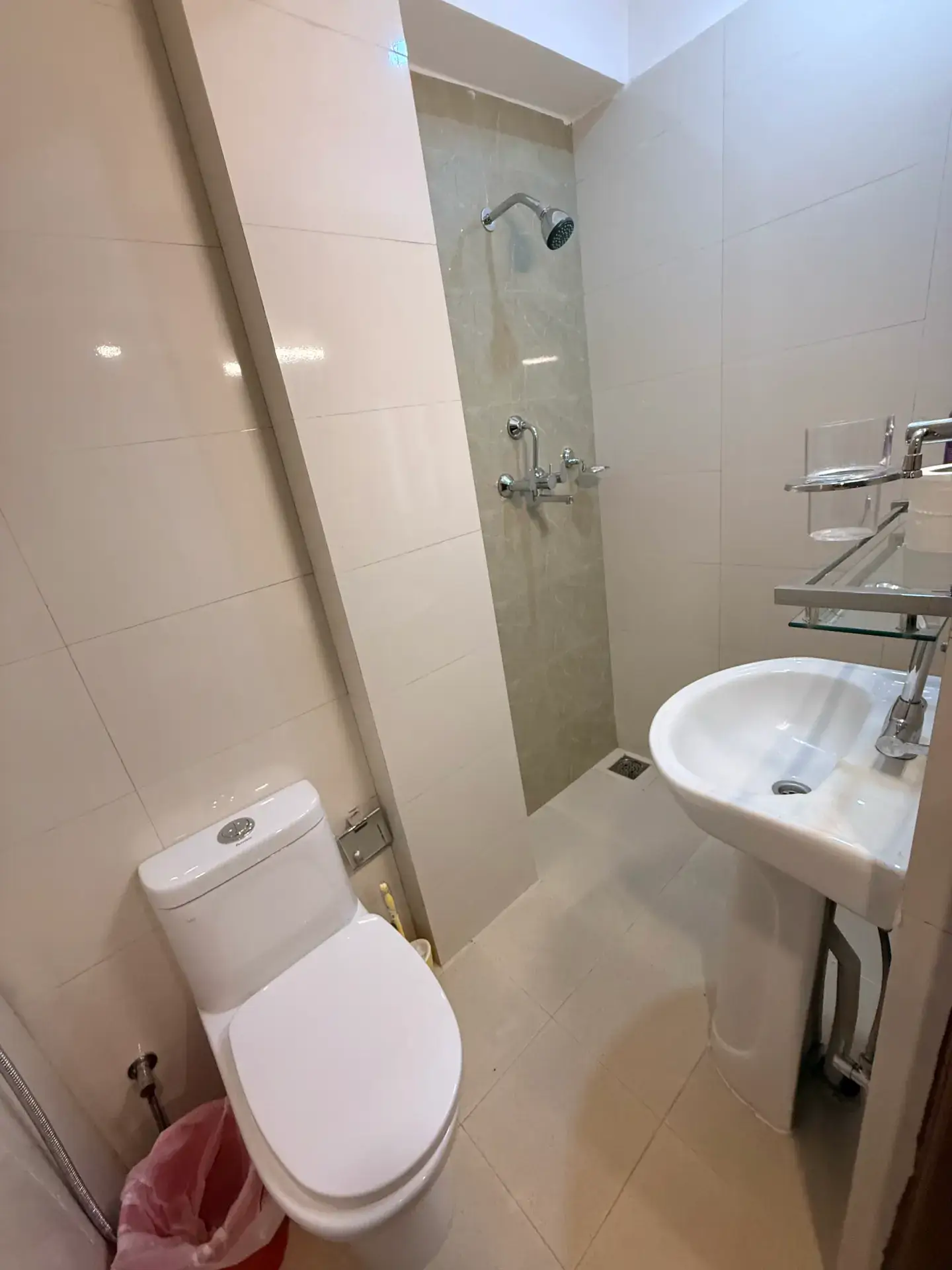 Tiled en-suite shower room with washbasin and towel rail