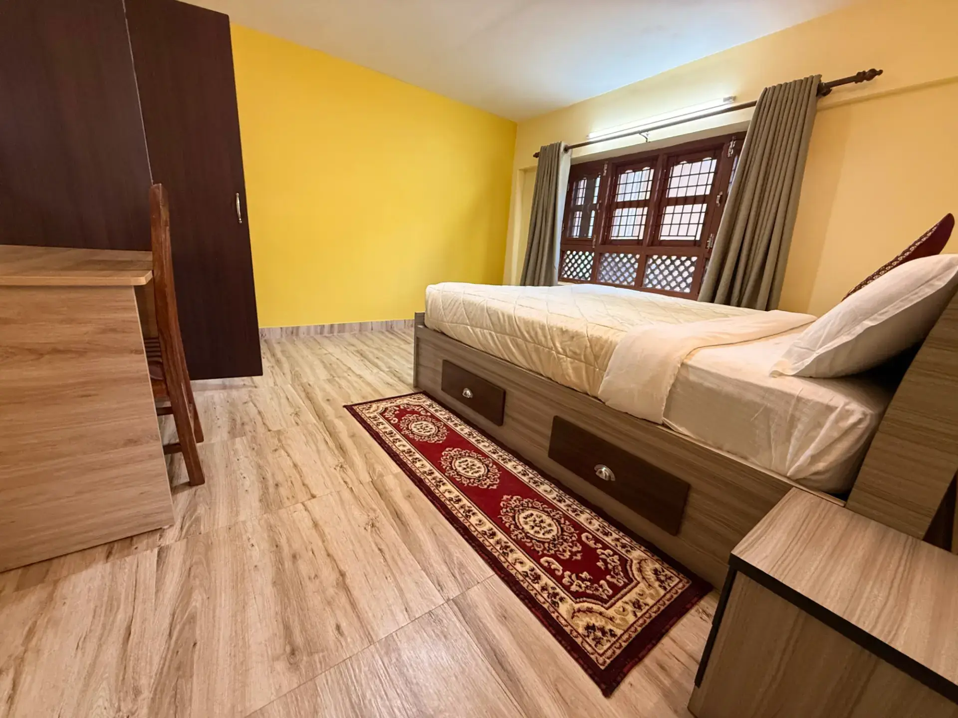 Apartment bedroom with double bed, rug and wardrobe