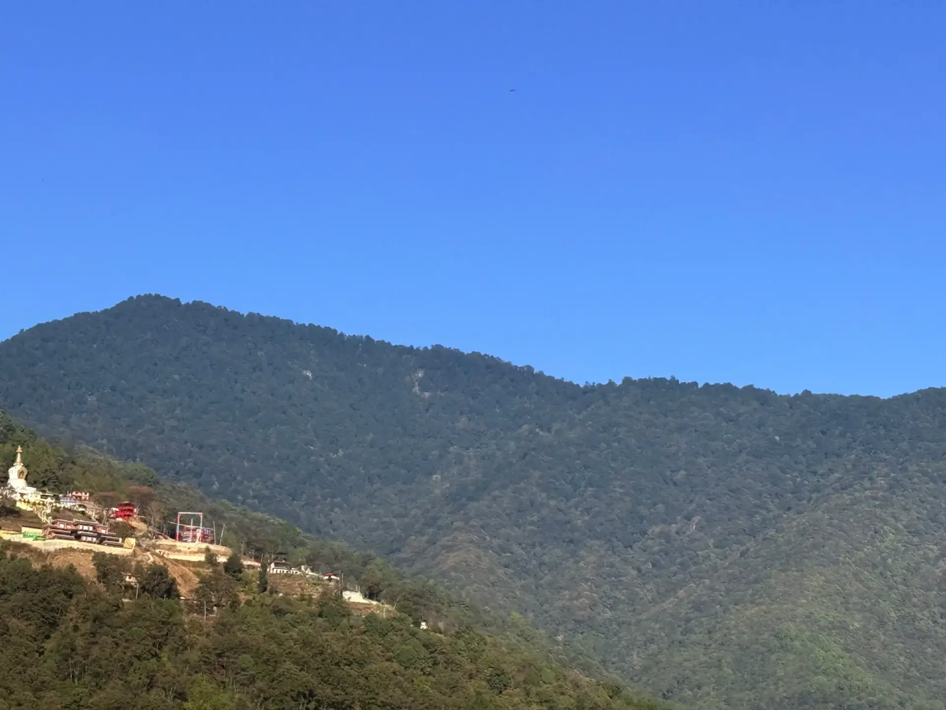 Shivapuri ridge and a hilltop monastery under blue sky