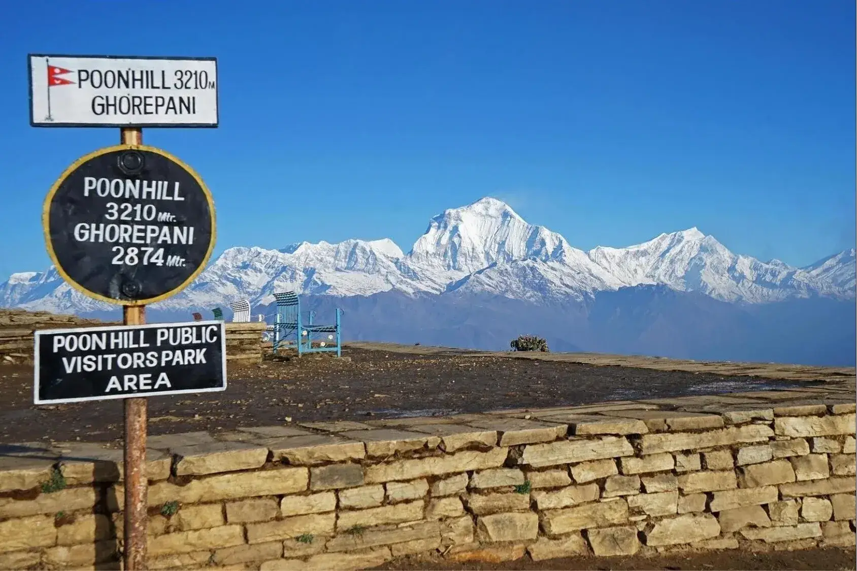 Poon Hill viewpoint sign at 3,210 m with the Dhaulagiri range behind